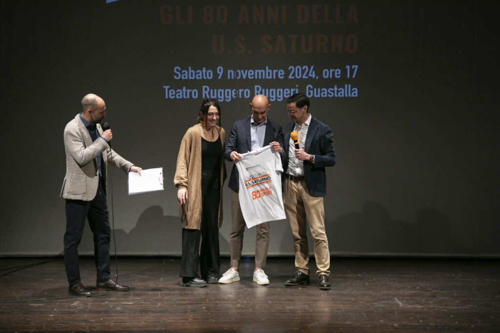 Il presdiente di Saturno, Alex Corradini, affiancato da Francesca Freddi istruttrice della ginnastica artistica consegna la maglia "80 voglai di sport" al sindaco Paolo Dallasta (foto Franzosi)